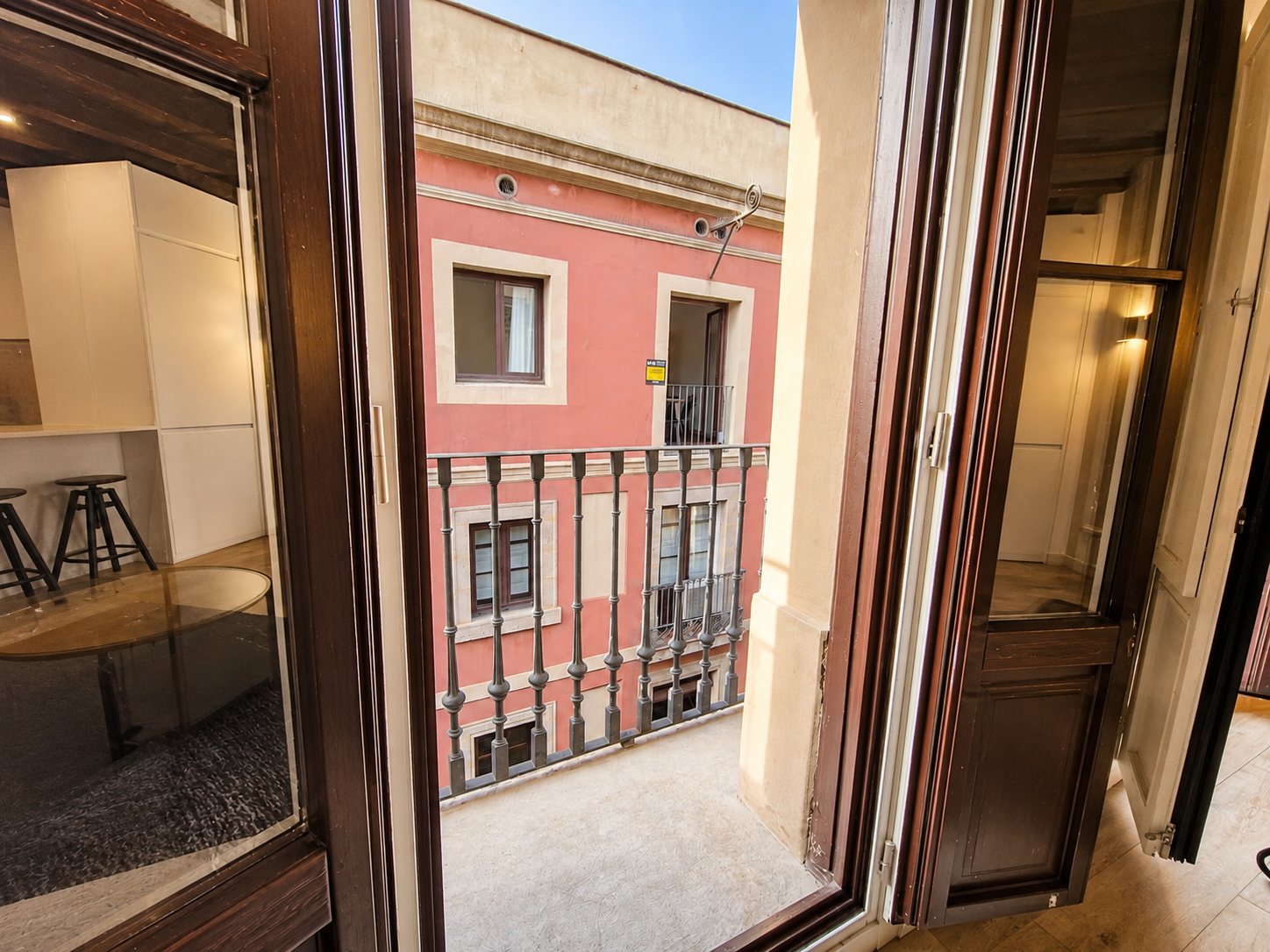 The balcony doors open from the living room, with the kitchen beyond