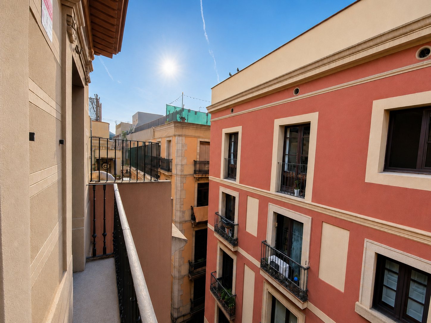 The view from the balcony along the sunlit street below