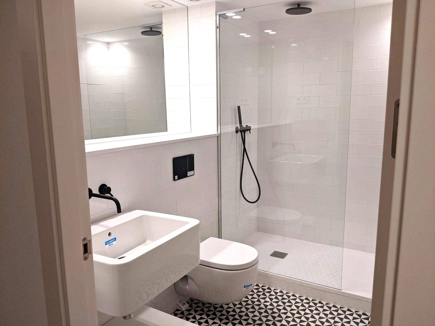Bathroom with walk-in rain shower and graphic cement floor tiles