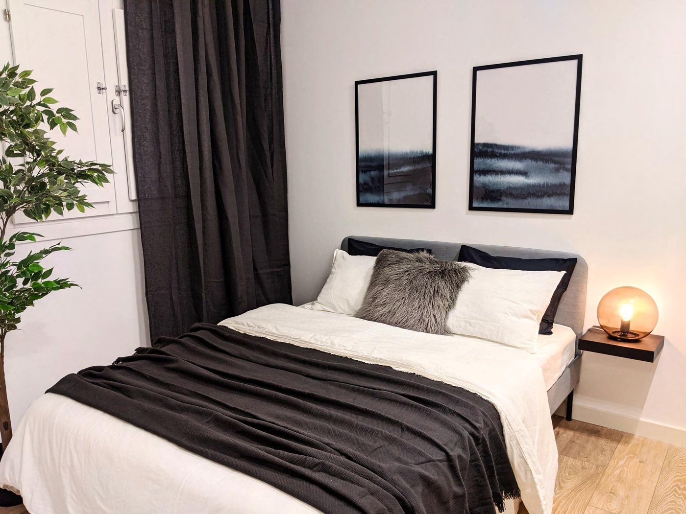 Second bedroom, styled, with framed prints and bedside lighting