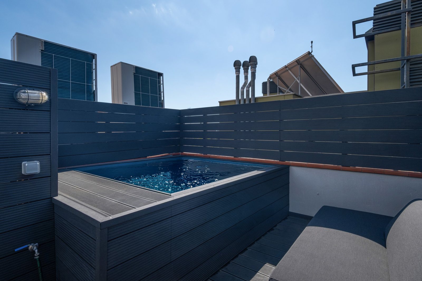 The jacuzzi position on the rooftop deck, screened on all sides — the unit is installed on completion as part of the sale